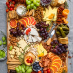Vegan meats, cheeses and fruit arranged to make a Vegan Charcuterie Board.
