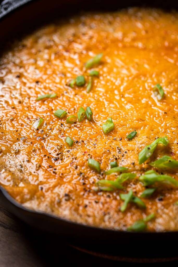 A skillet of Hot Vegan Crab Dip with green onions.